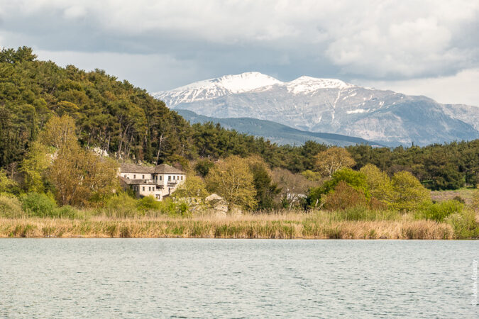 Monastery of Panagia Eleousa on the island in Lake Pamvotida, close to Ioannina in Northern Greece, with the mountains of Zagori behind. (Ap23)